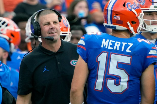 Florida coach Billy Napier, left, talks with quarterback Graham Mertz during a timeout during the Gators' 38-14 win Oct. 7 in Gainesville. (AP Photo/John Raoux)