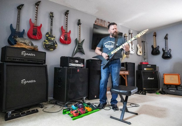 Robert Gully has had several careers, but now spends his days creating handmade guitars in his east Orlando home. He tries on out here. (Ricardo Ramirez Buxeda/ Orlando Sentinel)