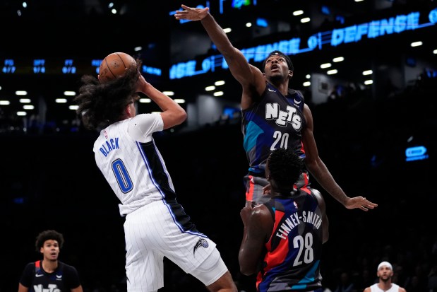 Brooklyn Nets' Day'Ron Sharpe (20) defends against a shot by Orlando Magic's Anthony Black (0) during the first half of an NBA basketball in-season tournament game Tuesday, Nov. 14, 2023, in New York. (AP Photo/Frank Franklin II)