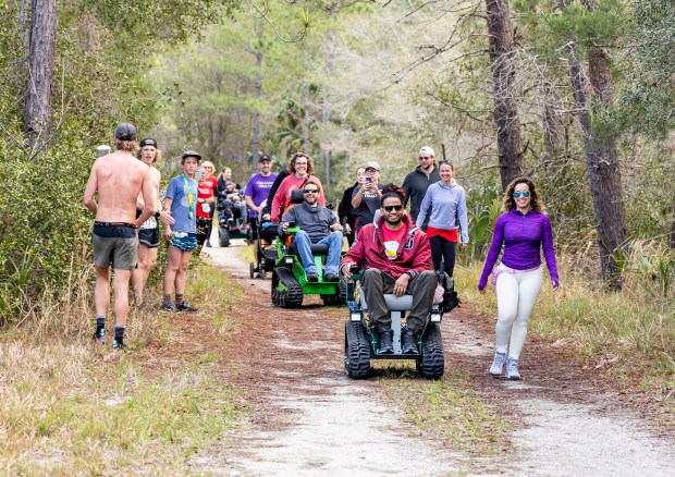 Tracked chair participants near the finish line during Friends of Seminole State Forest's Run for the Woods on Sunday, Feb. 12, 2023. The tracked chair program is open for the public to reserve a chair to use on the forest's trails on Saturdays and Sundays. (Patrick Connolly/Orlando Sentinel)
